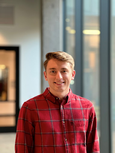 A photo of Justin Sindelar, who has brown hair and is wearing a plaid shirt.