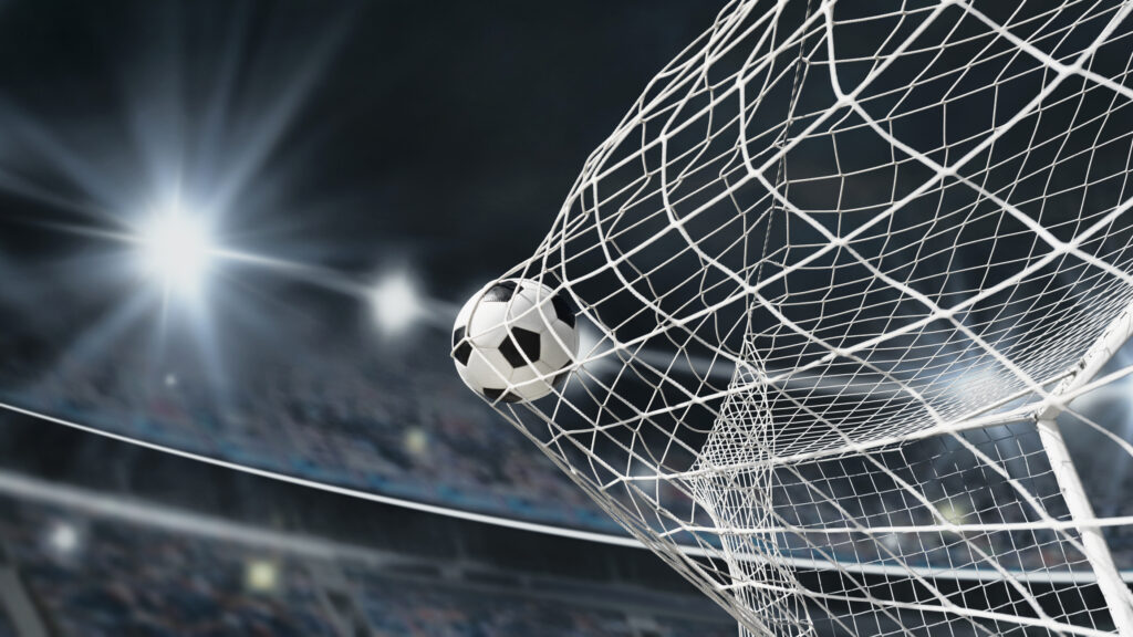 Soccer ball in soccer goal net . Close up textured soccer net on soccer goal in big stadium.