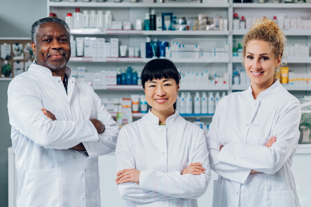 Multiracial pharmacists are standing in pharmacy.